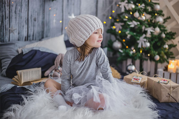 Ein Kind sitzt in mitten von Geschenken vorm Weihnachtsbaum | Bild: pixabay.com, Inhaltslizenz